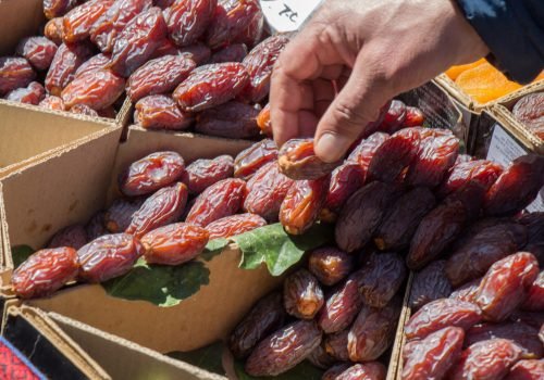 hand holding dates on a linen canvas background